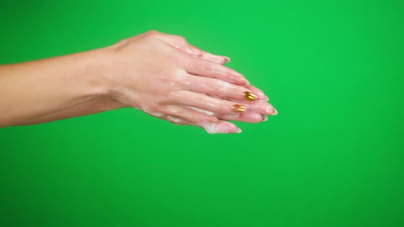 Washing Female Hands on Green Background Using Soap