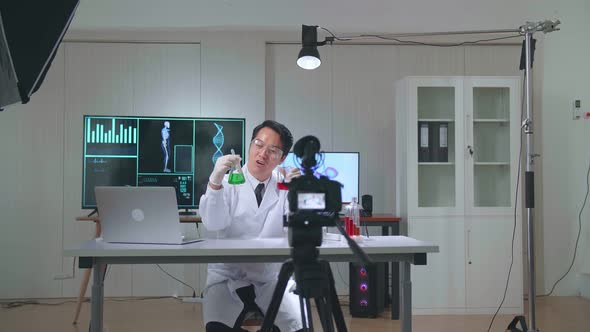 Research Scientist Holding Glass Test Tube And Speaking To The Camera With Professional Lighting alt