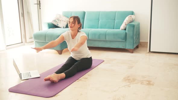 Attractive Young Woman Doing Yoga Stretching Yoga Online at Home.