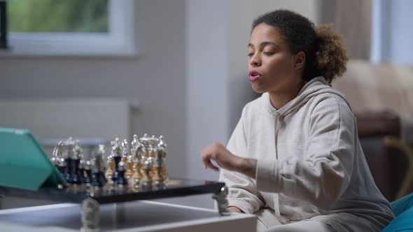 Focused Intelligent Player Making Move in Chess Game and Talking at Tablet Webcam