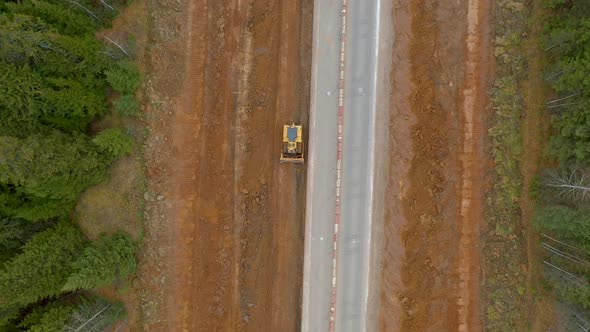Crawler Bulldozer Levels Ground Widening and Repairing Road Aerial Top Down