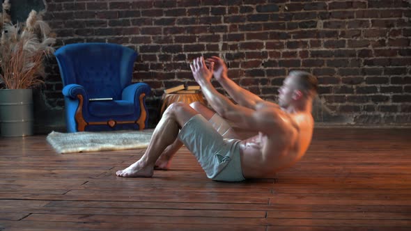 Sporty Man Doing Abs Exercises Crunches on Floor at Home Side View