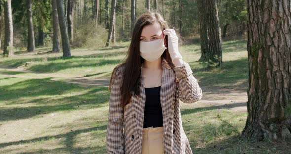 Portrait of a Young Woman Wearing Protective Mask in Coniferous Forest. Protection,covid-19