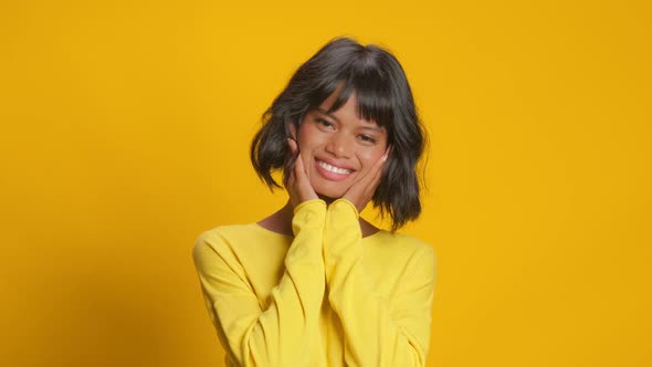 Surprised Joyful Ethnic Woman Looks Surprisingly Over Yellow Background