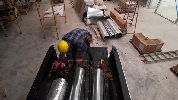 Construction HVAC Worker Unloading Pieces of Metal Air Duct Pipe