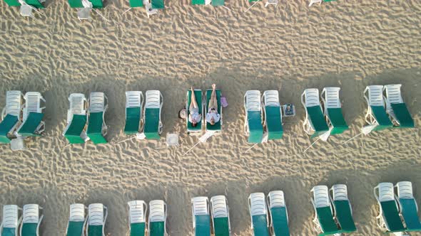 A Married Couple Lies on Sun Loungers on a Sandy Beach By the Sea