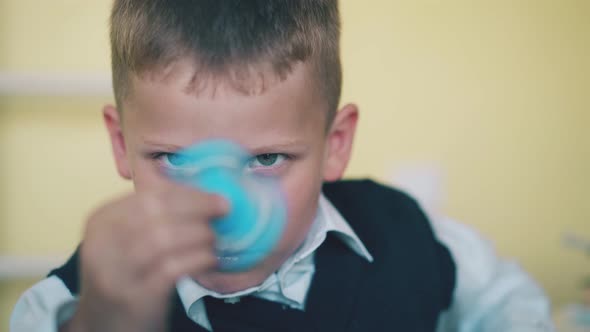 Funny Schoolkid Turns Blue Spinner on Blurred Background