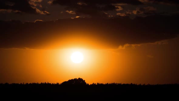 Dramatic Sunset Through the Clouds Above the Horizon, Timelapse