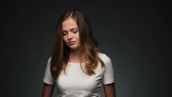 Portrait of Young Beautiful Caucasian Woman Nodding Head and Looking at Camera