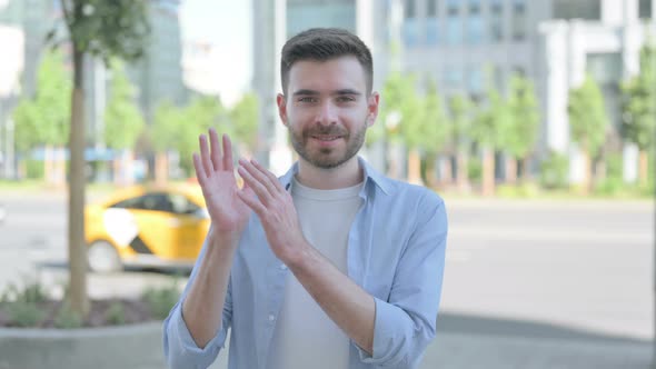 Young Man Clapping in Appreciation Outdoor