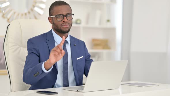 Serious African Businessman with Laptop Saying No By Finger Sign 