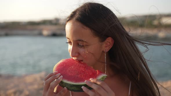 Brunette Teenage Girl Eating Watermelon in Slow Motion in Sunshine Outdoors