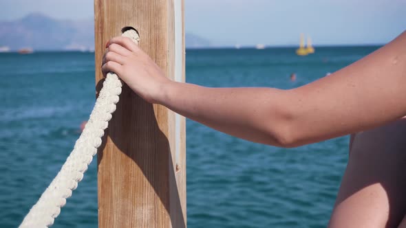 Girl Holding Rope On Pier. Woman Hand Holding Rope And Relish Holiday Vacation At Sea. Mediterranean