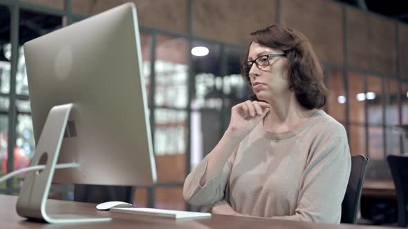 Pensive Senior Designer Thinking While Working on Computer