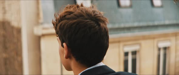 Back view of a young man staring outside in a windy day