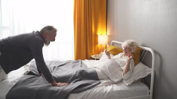 Happy Retired Man And Woman Having Fun In The Morning At Home