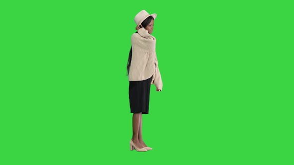 Fashionable African American Woman Posing in Knitwear and White Hat on a Green Screen Chroma Key