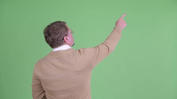 Rear View of Overweight Bearded Man Pointing Finger and Directing