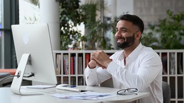 Happy Friendly Confident Successful Indian Businessman or CEO with a Beard Sitting in an Office