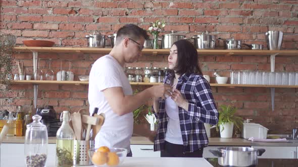 Sleepy or Hangover Man and Woman in the Morning Drinking Coffee in the Kitchen