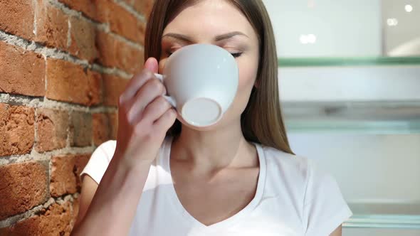 Portrait of Young Woman Drinking Coffee From Cup