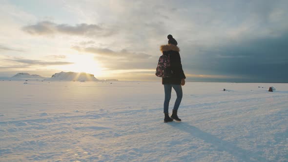 Yong Beautiful Woman Traveler Walking on Snow Desert in Iceland