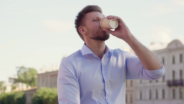 Caucasian Man Holding Disposable Cup of Coffee Outdoors