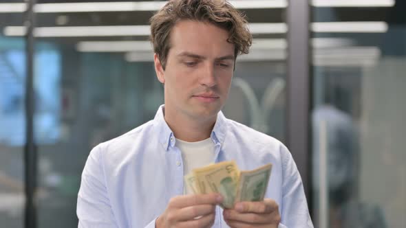 Portrait of Man Counting Dollars