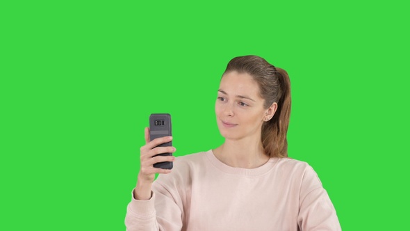 Smiling Young Woman Taking a Selfie Smiling on A Green