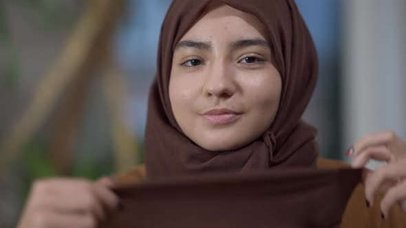 Closeup of Confident Beautiful Young Muslim Woman Hiding Face with Headscarf