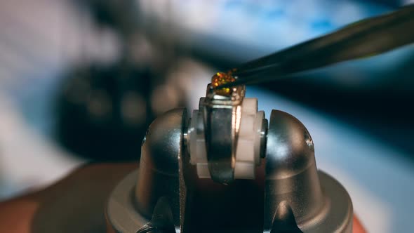 Professional Jeweller Works in a Jewellery Workshop, Putting a Stone on a Ring.