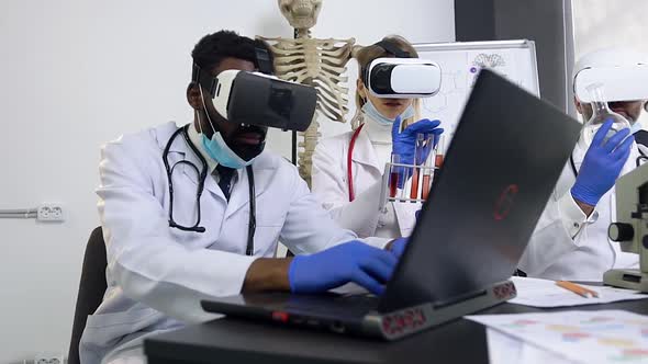 Medical Assistant in White Gown Working with Computer Using Augmented Reality Goggles