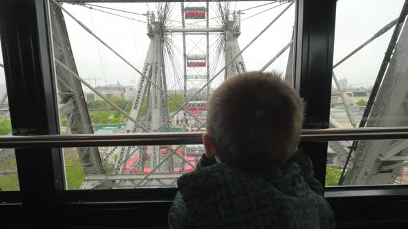 In Vienna, Austria from the window booths of the ferris wheel little boy looks at the city
