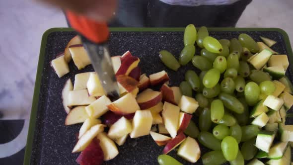 Young man making fruit salad. man holding knife on the chopping board