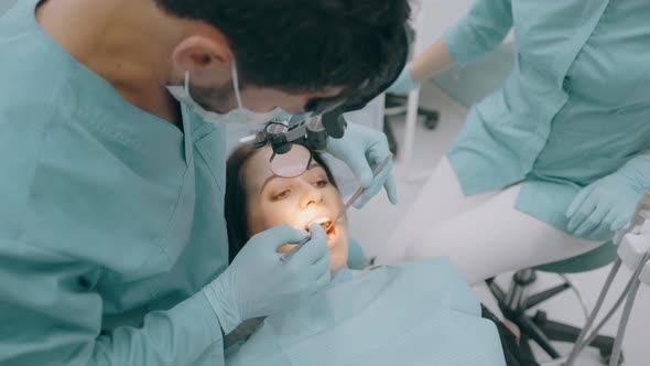 Dentist with Nurse and Patient in Dentist Office. A Patient Getting Dental Treatment at Dental