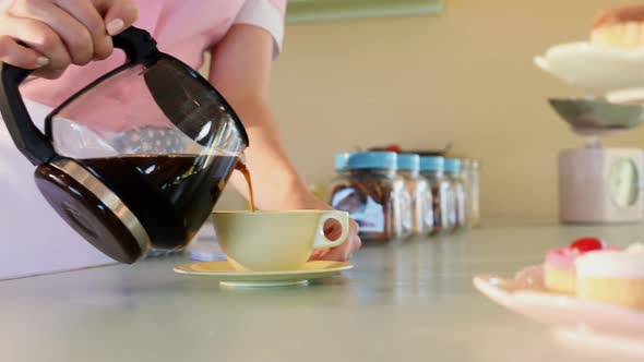 Waitress pouring black coffee in cup at restaurant 4k