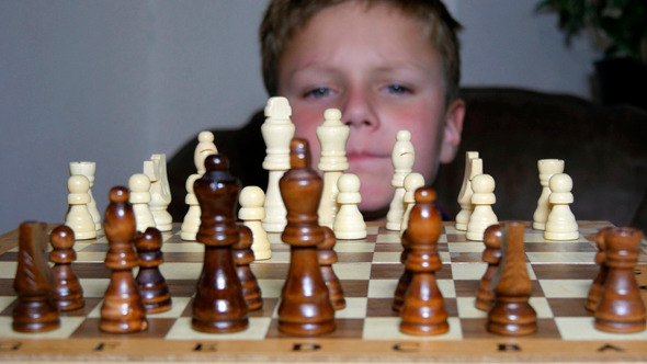 Little Boy Fascinated By The Game Of Chess