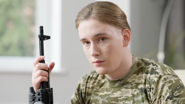 Portrait of Handsome Young Military Man with Rifle Gun Looking at Camera with Serious Facial