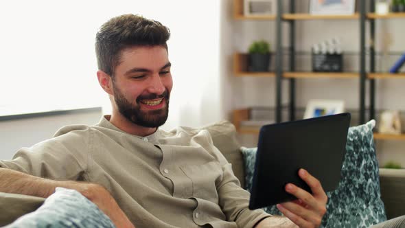 Man with Tablet Computer Having Video Call at Home