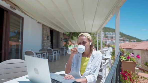 Pleased Woman Enjoying Morning Coffee While Sitting on Terrace with Sea View on Turkish Resort Using