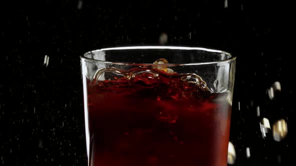 Ice Cube Falls in a Glass of Cola  Very Refreshing Slow Motion Shot