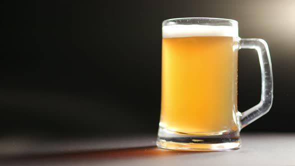 Big Mug of Fresh Craft Beer with Foam and Air Bubbles Isolated at Black Light Studio Background