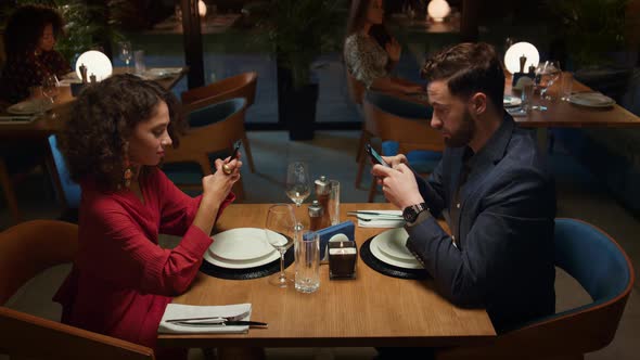 Couple Ordering Food Online at Fancy Restaurant Table on Romantic Evening Date