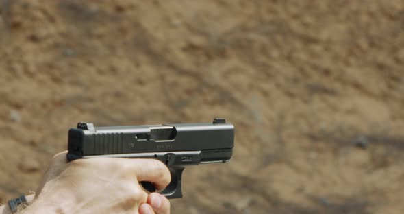 Pistol shooting bullets in slow motion footage. Hand guns in firing range