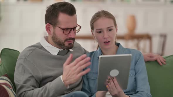 Couple Reacting to Loss on Tablet at Home