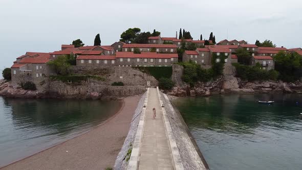 Crane Shot of an Island with Red Roof Houses in the Sea