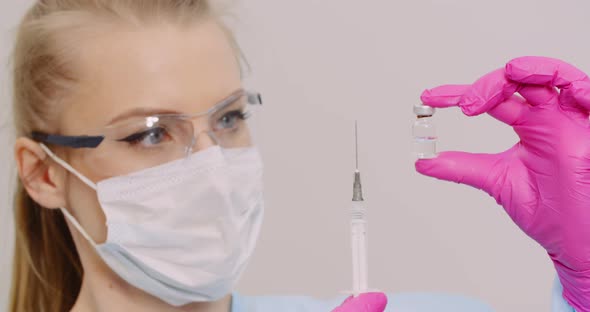 Doctor Holding Syringe and Vaccine in Hand