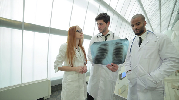Two Confident Doctor Examining X-ray Snapshot