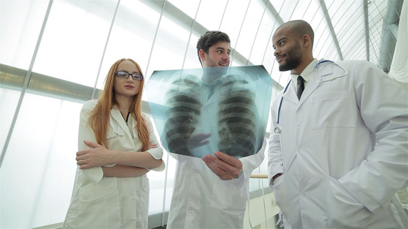 Three Confident Doctor Examining X-ray Snapshot