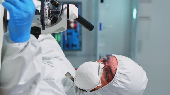 Vertical Video Scientist in Ppe Suit Placing a Slide on Specimen Stage